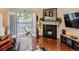 Cozy living room with hardwood floors, a fireplace, and a doorway leading to the patio at 11275 Holly St, Thornton, CO 80233