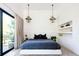 Bright bedroom with modern decor, bedside lamps, and sliding glass doors with a balcony view at 13905 Berry Rd, Golden, CO 80401