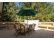 Outdoor patio with dining table and green umbrella under large trees at 13905 Berry Rd, Golden, CO 80401