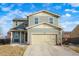 Two-story house with light green exterior, two-car garage, and landscaping at 334 Feather Pl, Lochbuie, CO 80603