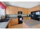 Kitchen with light wood cabinets, tile countertops, and black appliances at 3836 Garnet Way, Highlands Ranch, CO 80126