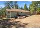 A view of the back of the property shows a spacious yard and a deck with table and chairs at 4185 Red Rock Dr, Larkspur, CO 80118
