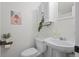 Small bathroom with a toilet, a sink, and white wooden storage cabinet above the toilet at 4185 Red Rock Dr, Larkspur, CO 80118