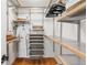 Walk-in closet with wooden floors, light wood shelves and metal rods for hanging clothing at 4185 Red Rock Dr, Larkspur, CO 80118
