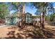 Charming green two-story home with brick foundation and a beautiful wooded front yard at 4185 Red Rock Dr, Larkspur, CO 80118