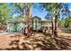 Charming two-story home nestled among mature trees, featuring a spacious deck and lush green surroundings at 4185 Red Rock Dr, Larkspur, CO 80118
