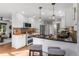 Well-lit kitchen with white cabinets, stainless steel appliances, and a breakfast bar at 4185 Red Rock Dr, Larkspur, CO 80118