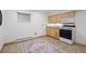 Cozy kitchenette with wooden cabinets, a black stove and oven, and tile floors with a rug at 4185 Red Rock Dr, Larkspur, CO 80118