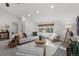 Bright living room features white sofas, a woven rug, and windows with views of the trees at 4185 Red Rock Dr, Larkspur, CO 80118