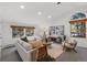 Bright living room features white sofas, woven rug, and windows with wood frames overlooking the trees at 4185 Red Rock Dr, Larkspur, CO 80118