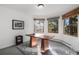 Home office with a modern desk, plush rug, and views from three windows at 4185 Red Rock Dr, Larkspur, CO 80118