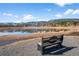 A peaceful view of the pond and hills from the community area with a bench for enjoying the scenery at 4185 Red Rock Dr, Larkspur, CO 80118