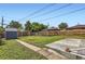 Green backyard with a shed, clothesline, and wooden fencing surrounding the yard at 925 Wolff St, Denver, CO 80204