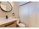 Updated bathroom featuring a modern vanity, sleek fixtures, and a stylish, round mirror at 925 Wolff St, Denver, CO 80204