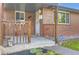 Classic covered front porch with brick accents and a secure entrance at 925 Wolff St, Denver, CO 80204
