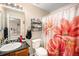 Bathroom featuring a floral shower curtain, updated sink, and mirrored vanity at 814 Pintail Ave, Brighton, CO 80601