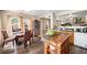 Open kitchen and dining area with island, wood cabinets, and natural light at 814 Pintail Ave, Brighton, CO 80601