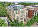 Aerial view of a multi-story building with balconies, rooftop decks, surrounded by green trees and neighborhood streets at 340 S Lafayette St # 204, Denver, CO 80209