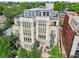 Aerial view of a multi-story building with balconies, surrounded by lush green trees and landscaping at 340 S Lafayette St # 204, Denver, CO 80209