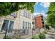 Exterior view of a condo building with metal railings, patio furniture, and a brick building in the background at 340 S Lafayette St # 204, Denver, CO 80209