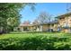 Spacious backyard with lush green lawn, mature trees, and an outdoor patio area at 2330 Yarrow St, Lakewood, CO 80214