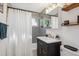 Modern bathroom featuring grey tile, updated vanity, stylish fixtures, and a shower-tub combination at 2330 Yarrow St, Lakewood, CO 80214