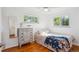 Comfortable bedroom with hardwood floors, bright windows, and a stylish vintage dresser at 2330 Yarrow St, Lakewood, CO 80214