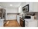 Modern kitchen features stainless steel appliances, white cabinets, and ample counter space at 2330 Yarrow St, Lakewood, CO 80214