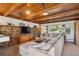 Spacious living room with bright windows, wood-beam ceilings, stone accent wall, and comfortable sectional sofa at 2330 Yarrow St, Lakewood, CO 80214