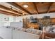 Inviting living room with wood-beam ceilings, stone accent wall, and comfortable sectional sofa at 2330 Yarrow St, Lakewood, CO 80214