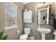 Charming half bathroom featuring a pedestal sink, modern fixtures, and a window with views at 1432 Red Mica Way, Monument, CO 80132