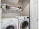 Functional laundry room with washer, dryer, and shelving for organized storage and efficiency at 1432 Red Mica Way, Monument, CO 80132