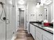 Bathroom featuring double sinks, granite countertops, and a glass door shower at 6712 Sea Oats Dr, Parker, CO 80138
