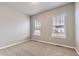 Cozy bedroom with neutral carpet, two large windows, and ample natural light at 6712 Sea Oats Dr, Parker, CO 80138