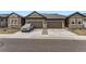 Street view of homes with well-manicured lawns, stone accents, and two-car garages at 6712 Sea Oats Dr, Parker, CO 80138