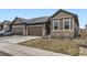 Charming home featuring a two-car garage, stone accents, and well-maintained landscaping at 6712 Sea Oats Dr, Parker, CO 80138