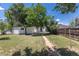 Expansive backyard with mature trees, a path to the detached garage, and wood fence at 1900 Kingston St, Aurora, CO 80010