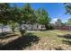 The fenced backyard with lush green grass and shade trees offers privacy and outdoor space at 1900 Kingston St, Aurora, CO 80010