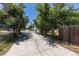 A driveway flanked by chain link and wooden fences leads to the back of the property at 1900 Kingston St, Aurora, CO 80010