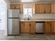 Bright kitchen with stainless steel appliances, light wood cabinetry, and a window over the sink at 1900 Kingston St, Aurora, CO 80010