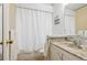 Bathroom with tile countertop, white vanity, large mirror and shower with white curtain at 7735 Westview Dr, Lakewood, CO 80214