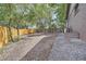 Spacious backyard featuring a gravel area, brick siding, wood fence, and mature trees; great for landscaping or outdoor activities at 10472 Lincoln Ct, Northglenn, CO 80233