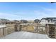 The outdoor wooden deck with stone pillars overlooks neighboring homes and a large open field at 6614 S Vandriver Way, Aurora, CO 80016