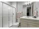 Clean bathroom featuring glass enclosed shower, neutral gray vanity and a white toilet at 6614 S Vandriver Way, Aurora, CO 80016