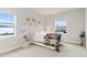 A bedroom showcasing neutral walls, carpet, a large window, a bed with blanket, and decorated walls and shelving at 6614 S Vandriver Way, Aurora, CO 80016