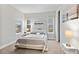 This bedroom features neutral walls, carpet, three windows with blinds, a bed with side tables and artwork hanging on the walls at 6614 S Vandriver Way, Aurora, CO 80016