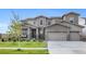 Stunning two-story home featuring a three-car garage, stone accents, covered porch and well-manicured lawn at 6614 S Vandriver Way, Aurora, CO 80016
