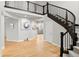 Bright foyer featuring a staircase with dark wood banister and light wood floors at 6614 S Vandriver Way, Aurora, CO 80016