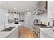 Bright kitchen with stainless appliances, range hood, and large island with quartz countertops at 6614 S Vandriver Way, Aurora, CO 80016
