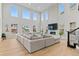 Open living room with large sectional, gas fireplace, and large windows for abundant natural light at 6614 S Vandriver Way, Aurora, CO 80016